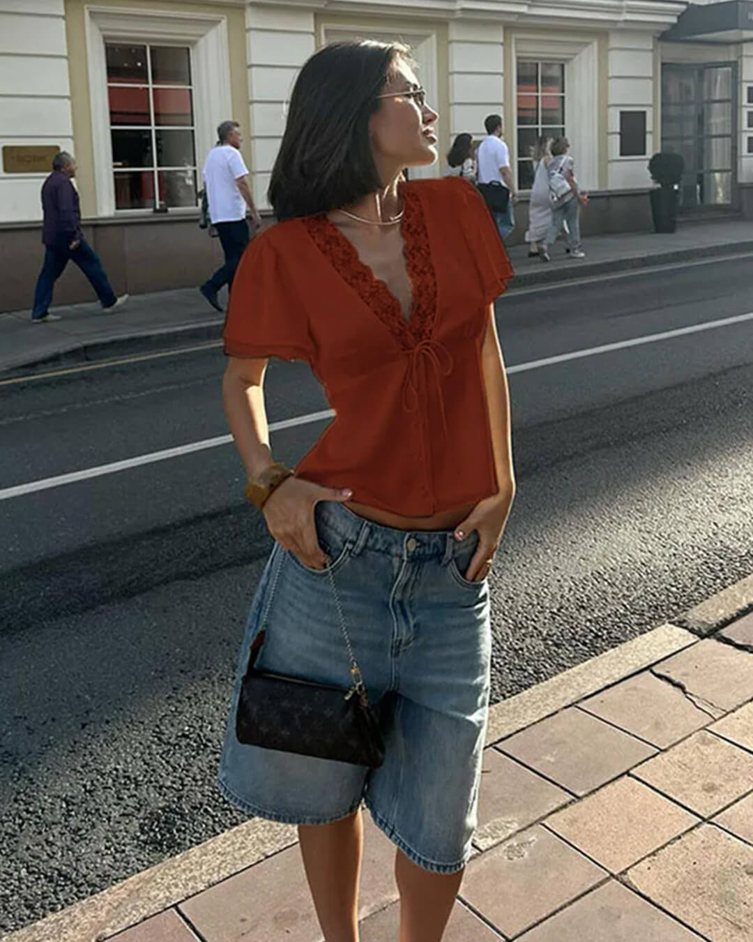 Blouse en dentelle à manches courtes avec col en V et rosettes