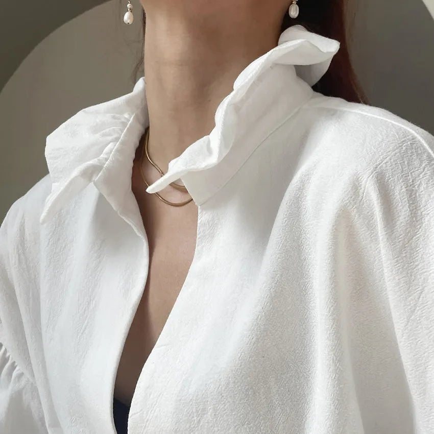 Lola Blouse à col V. Manches bouffantes. Manches longues.